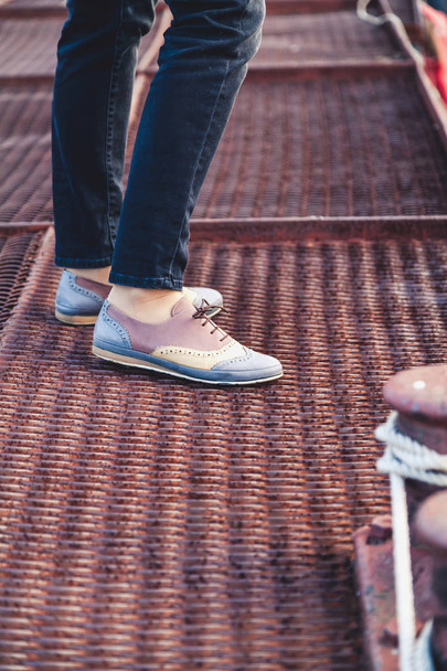 Female feet in the pants and shoes on the dock - Photo, Image