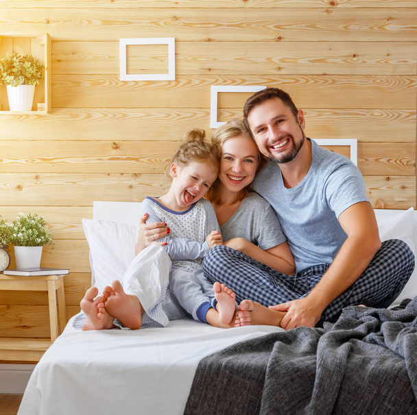 happy family mother, father and child   laughs in bed - Foto, Imagem