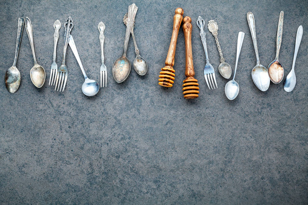 Various cooking utensils border. Spoons and fork on dark stone b - Photo, Image