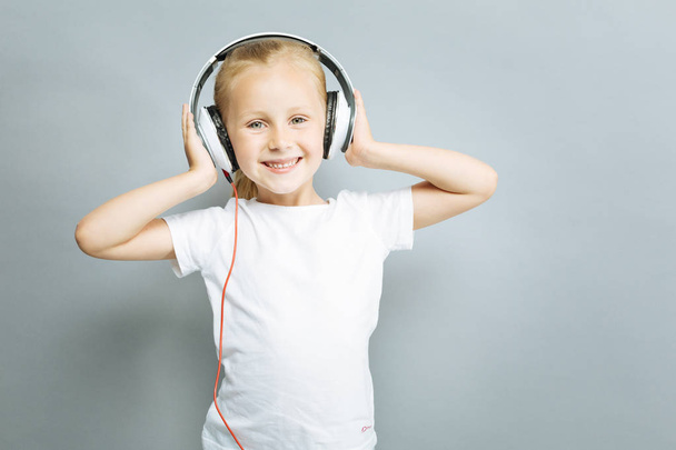 Pozitivní radost dítěte dotýkat její sluchátka - Fotografie, Obrázek