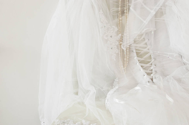Beautiful white wedding dress and veil on chair - Foto, Imagem