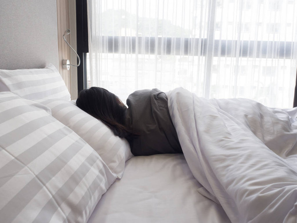 Arkadan Görünüm, uyanma sonra yatakta uzanan kadın - Fotoğraf, Görsel