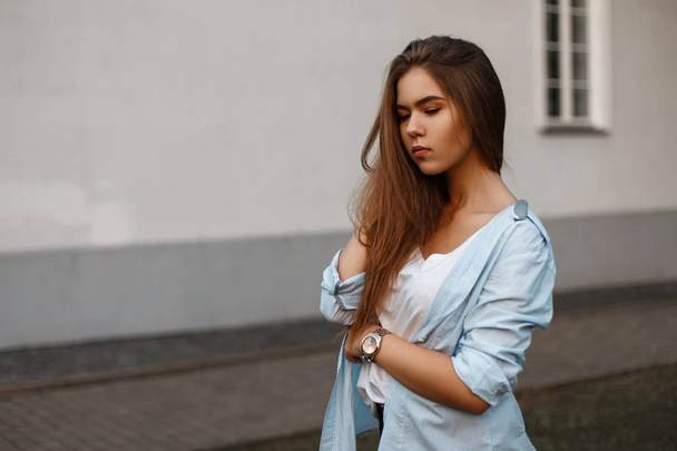 Όμορφο νεαρό μοντέλο κορίτσι σε ένα στυλ casual ένδυσης καλοκαίρι κοντά στον τοίχο ενός σπιτιού - Φωτογραφία, εικόνα