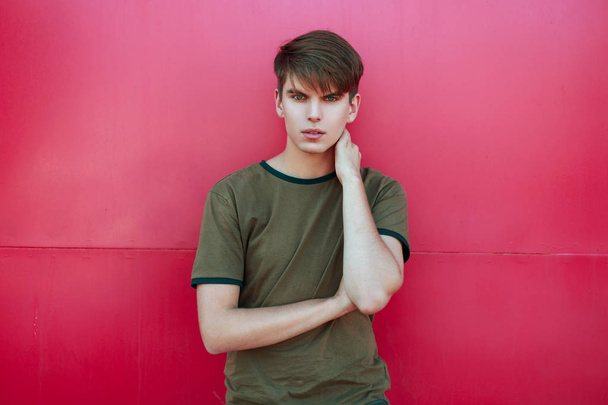 handsome young man in trendy summer clothes near a bright pink wall - Fotoğraf, Görsel