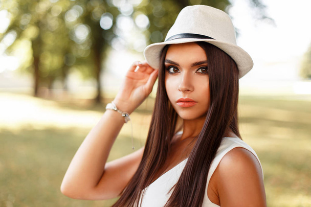 Beautiful serious girl with makeup in white dress on a summer day in the park - Foto, immagini