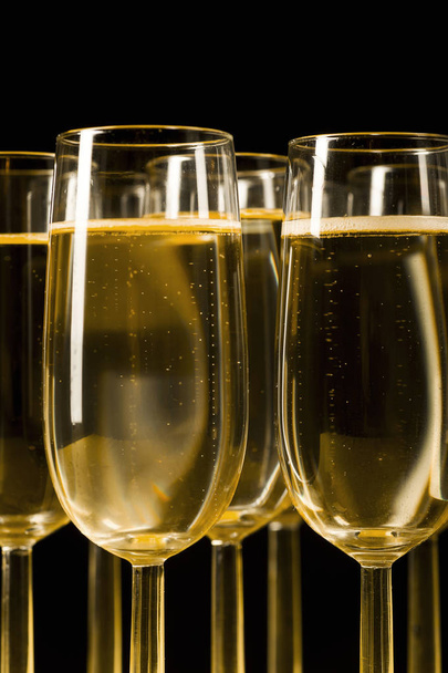 Copos de champanhe em isolado no fundo preto
  - Foto, Imagem