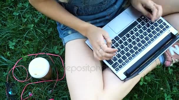 girl with laptop sitting on a grass - Materiaali, video