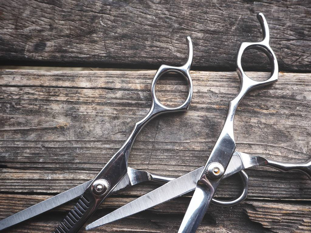 Pair of hair cutting shears on wooden background - Фото, зображення