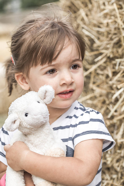 little girl with toy lamb - Фото, изображение