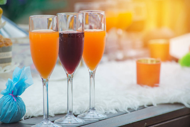 Ποτήρια κρασιά και χυμό πορτοκαλιού στο τραπέζι για το κόμμα το βράδυ - Φωτογραφία, εικόνα