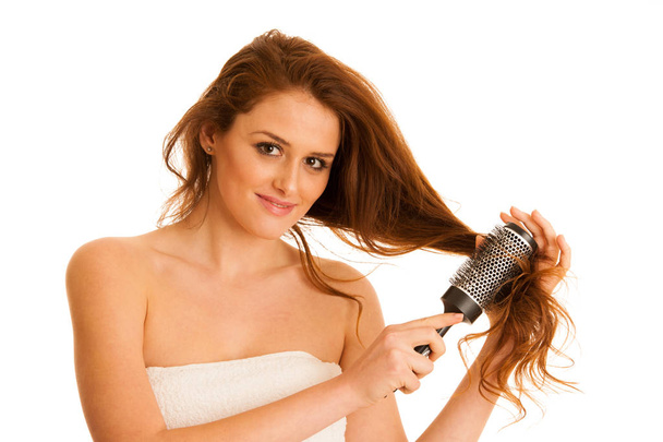 Beautiful young woman combs her hair with a brush isolated over  - Foto, afbeelding