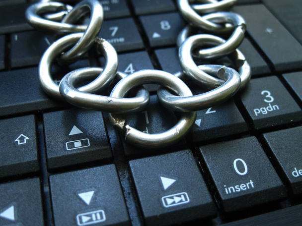 Chain on laptop keyboard. Computer ban, internet ban. Addiction. Anti virus - Photo, Image