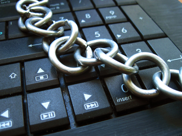 Chain on laptop keyboard. Computer ban, internet ban. Addiction. Anti virus  - Photo, Image