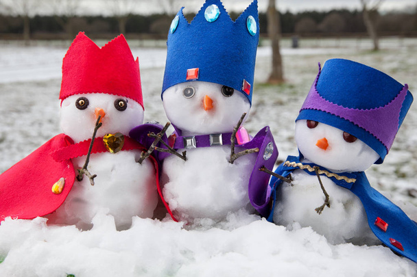 Drie sneeuwmannen koningen gekleed met kronen en capes - Foto, afbeelding