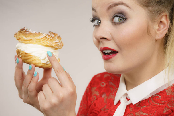 Funny woman holds cream puff cake - 写真・画像