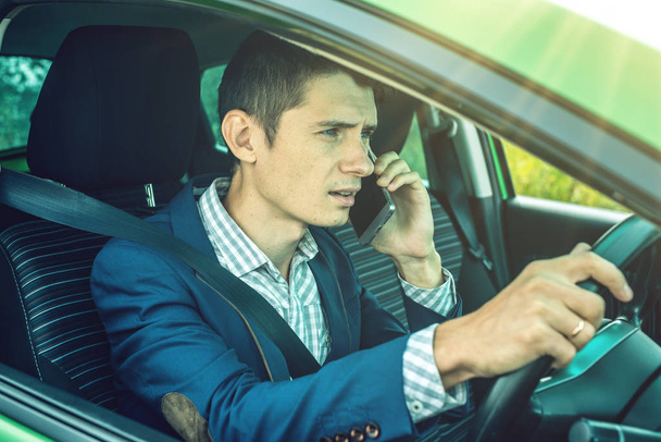 Hombre conductor hablando por teléfono en el coche. Conducción distraída y peligrosa. La violación de tráfico
. - Foto, imagen