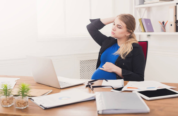 Tired pregnant businesswoman at office copy space - Foto, Imagem