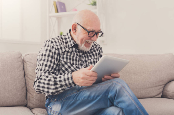 Senior man leest Nieuws op digitale Tablet PC - Foto, afbeelding