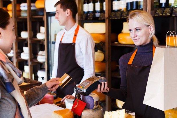 Πελάτης που πληρώνει για την παραγγελία του τυριού στο κατάστημα παντοπωλείων. - Φωτογραφία, εικόνα