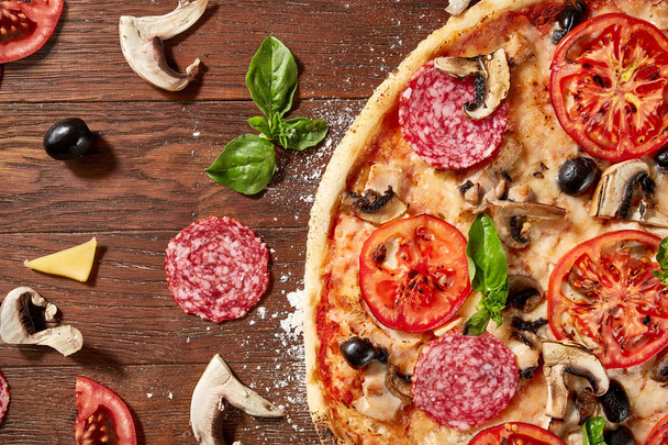 delicious italian pizza served on wooden table - Foto, afbeelding