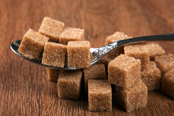 столовая ложка с кубиками коричневого сахара
 - Фото, изображение