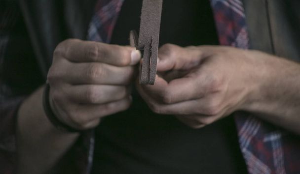 Close up of piece of leather in man hands leather worker cuts into thin strips - Photo, Image