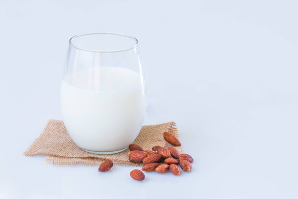 Amandel melk in een glas met amandel zaden op marmeren tafel.  - Foto, afbeelding