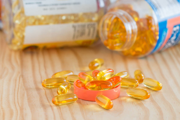 Olio di pesce, omega 3 con capsule di vitamina D sul tavolo di legno
.  - Foto, immagini