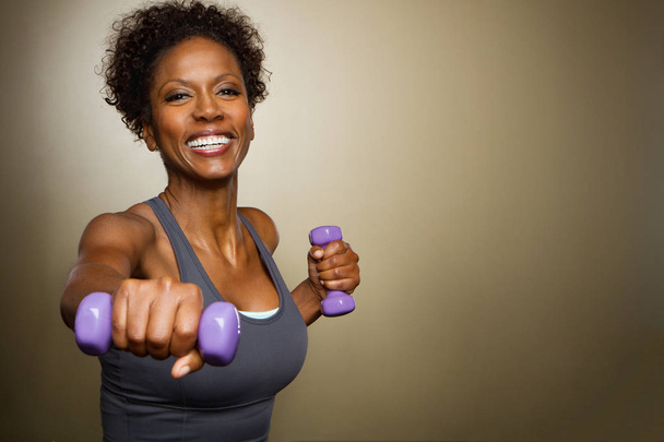 African American woman lifting weights. - 写真・画像