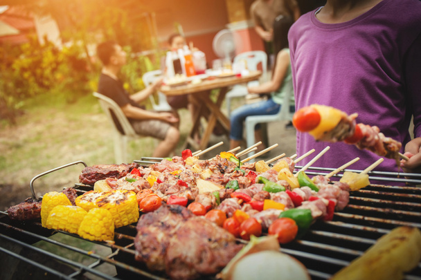 Grillausjuhla kesä grillaa lihaa iltapäivällä viikonloppuna aasialaisten onnellinen juhla perhe
. - Valokuva, kuva
