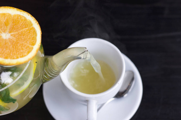 A narancssárga gyógynövény forró tea öntötte a csésze - Fotó, kép