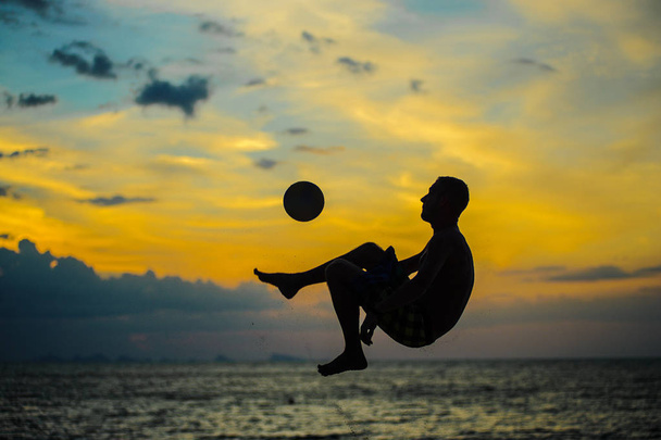 Kopanie piłki. Sylwetka człowieka na plaży - Zdjęcie, obraz