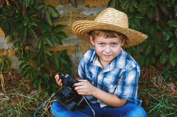 Un niño pequeño con una vieja cámara. Joven fotógrafo alegre
 - Foto, imagen