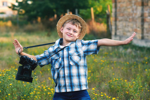 Un niño pequeño con una vieja cámara. Joven fotógrafo alegre
 - Foto, imagen