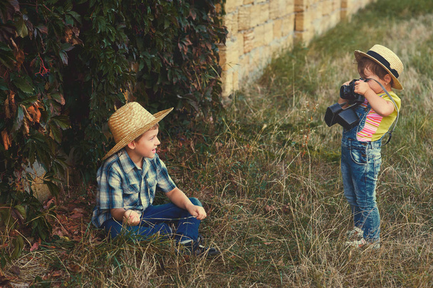 兄と散歩に古いカメラで妹。若い陽気な写真家 - 写真・画像