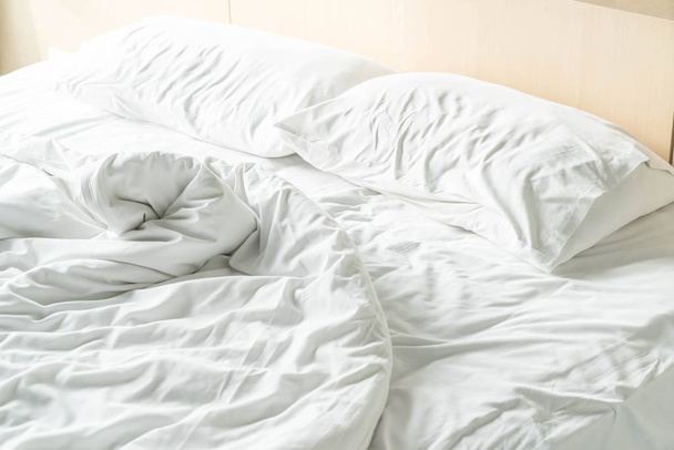 rumpled bed with white messy pillow  - Φωτογραφία, εικόνα