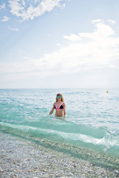 Beautiful model relaxing on a beach dressed in a swimsuit. - Foto, Bild