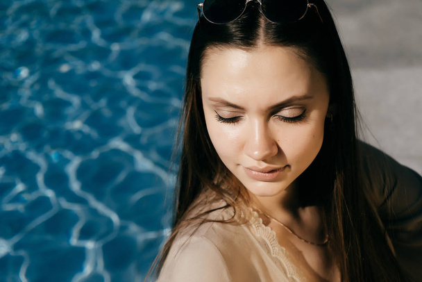 Beautiful girl reflected on the background of the pool - Foto, imagen