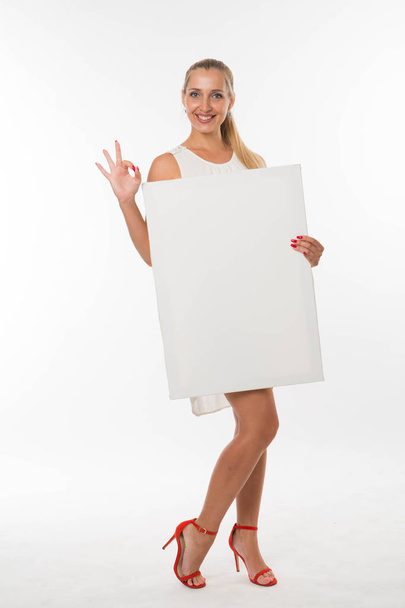 Young happy woman showing presentation, pointing on placard. - Foto, Imagen