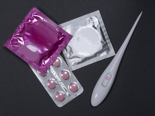 Raskaustesti kondomilla ja ehkäisypillerillä. raskaana oleva nainen. terveydenhuollon käsite
 - Valokuva, kuva