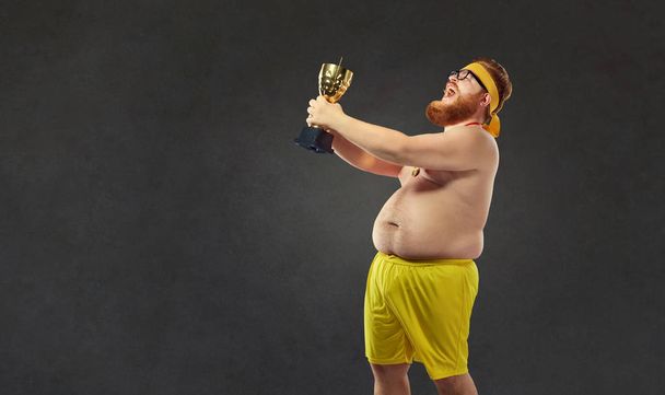 A fat naked man with a champions cup in his hands. - Fotoğraf, Görsel