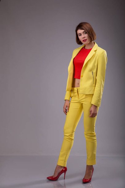 Glamour fashion style catalog casual clothes for business woman meeting date walk party sexy beautiful woman brunette shot hair wear yellow costume perfect body shape model suit - Фото, зображення