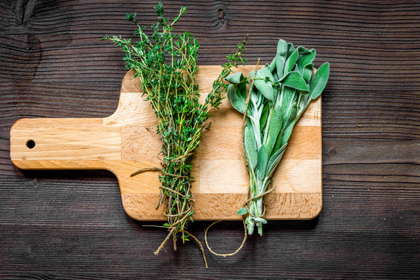 bundle of sage and thyme on wooden board top view - Valokuva, kuva