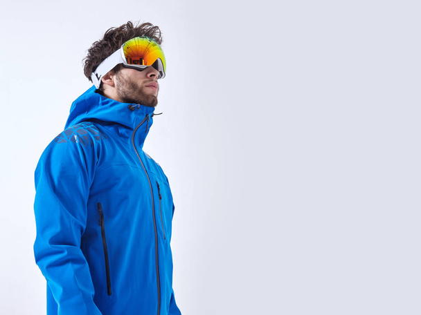The mountaineer in winter clothes and ski ultraviolet protected mask on white isolated background - Photo, Image