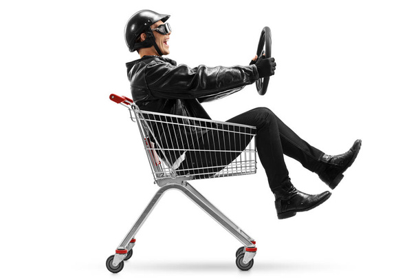 Biker riding in shopping cart with steering wheel - Valokuva, kuva