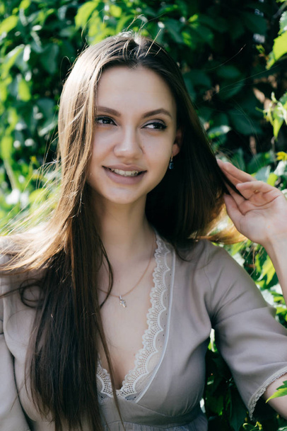Beautiful girl on a plant background smiling - Zdjęcie, obraz
