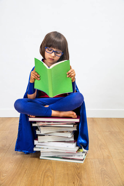 superhero girl reading books for studying power and female imagination - Photo, Image