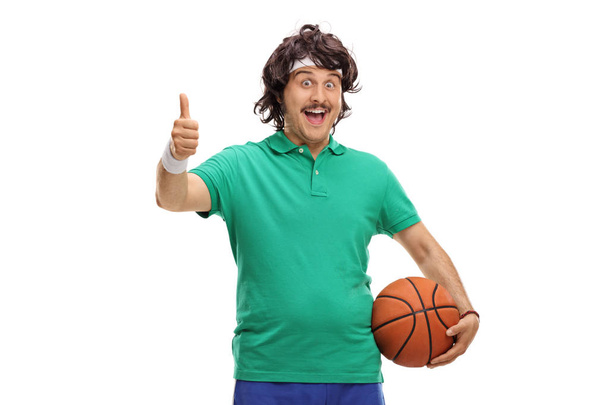 sportsman holding basketball and making thumb up sign - Fotó, kép