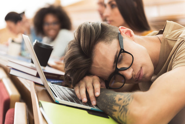 Aburrido estudiante masculino durmiendo en conferencia
 - Foto, imagen
