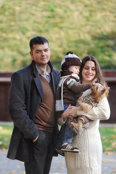 Retrato de familia feliz de tres de pie juntos en el parque de otoño
        - Foto, imagen